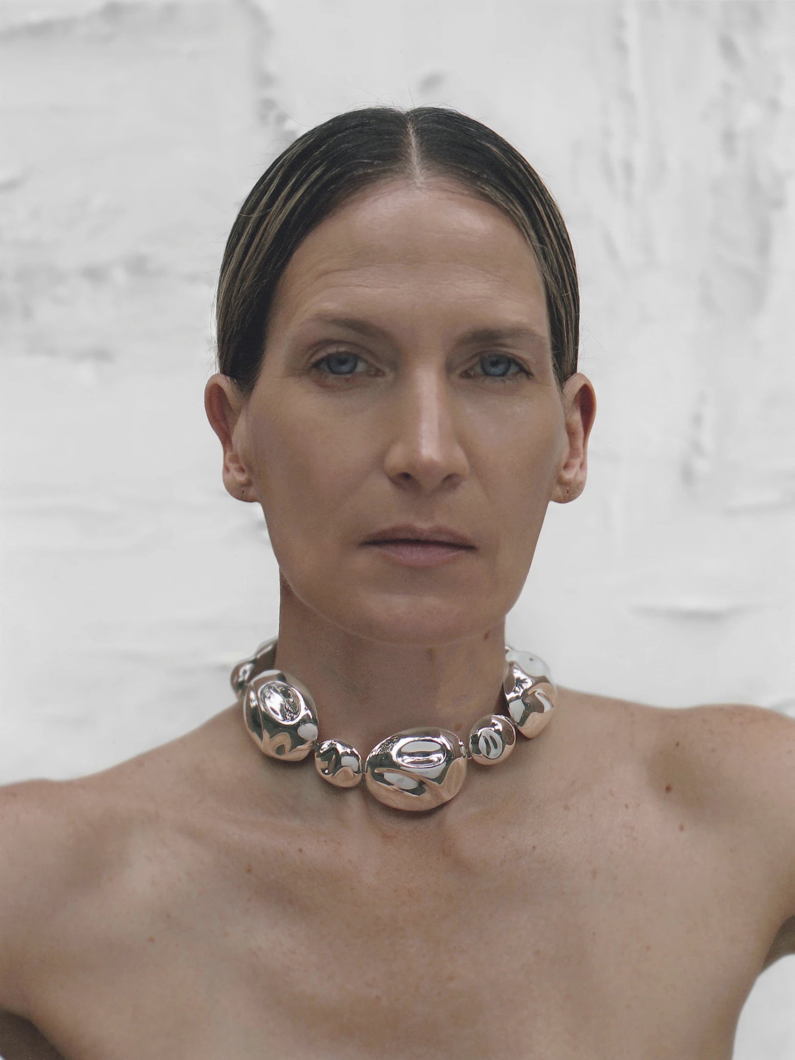 Light-skinned model showcasing the silver statement necklace front-on, styled for an elegant editorial look.