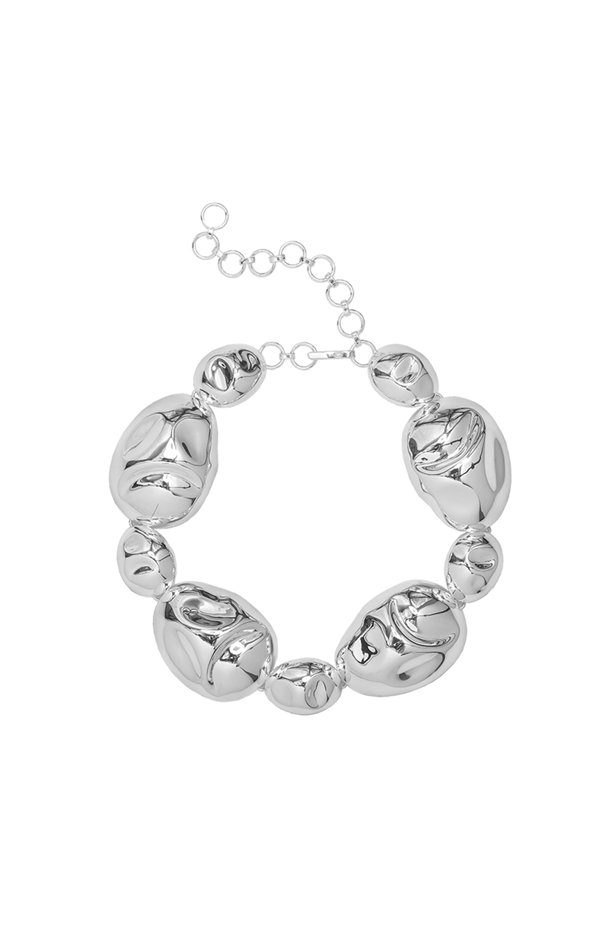 Sculptural statement necklace in silver-plated brass with bold interlocking forms and an adjustable hook closure.