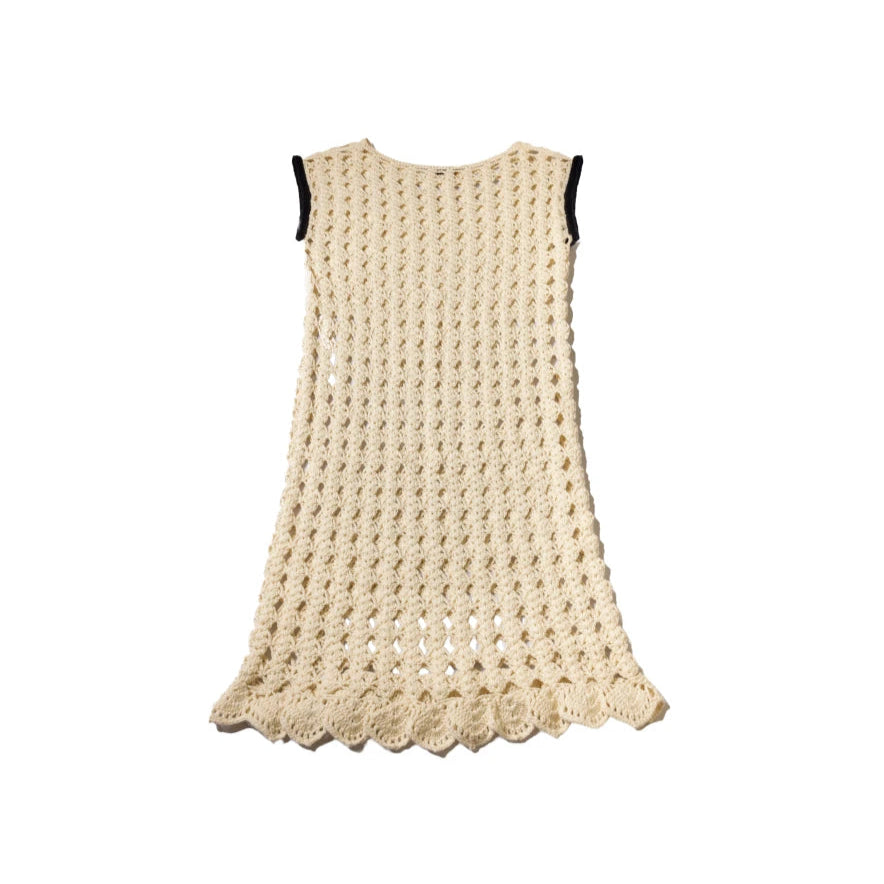 Front view of the Mira dress displayed flat on a white background, showcasing its hand-crocheted pima cotton texture, scalloped hem, and sleeveless silhouette with black armhole edging.