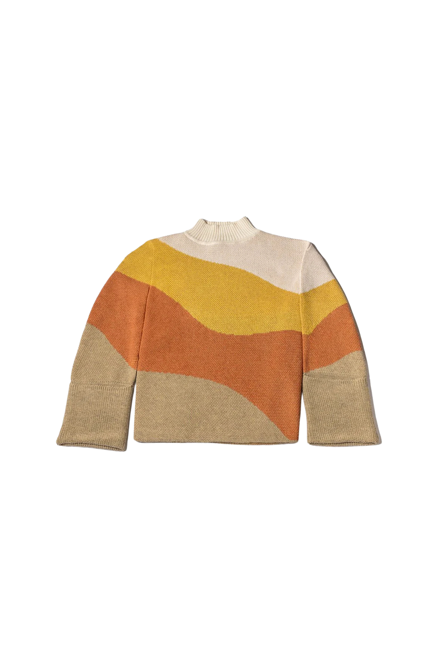 Flat lay of the My Paloma colourblock knit sweater featuring a soft crew neckline and sweeping wave pattern in cream, mustard, terracotta, and sand tones—crafted for luxury comfort and global style appeal.